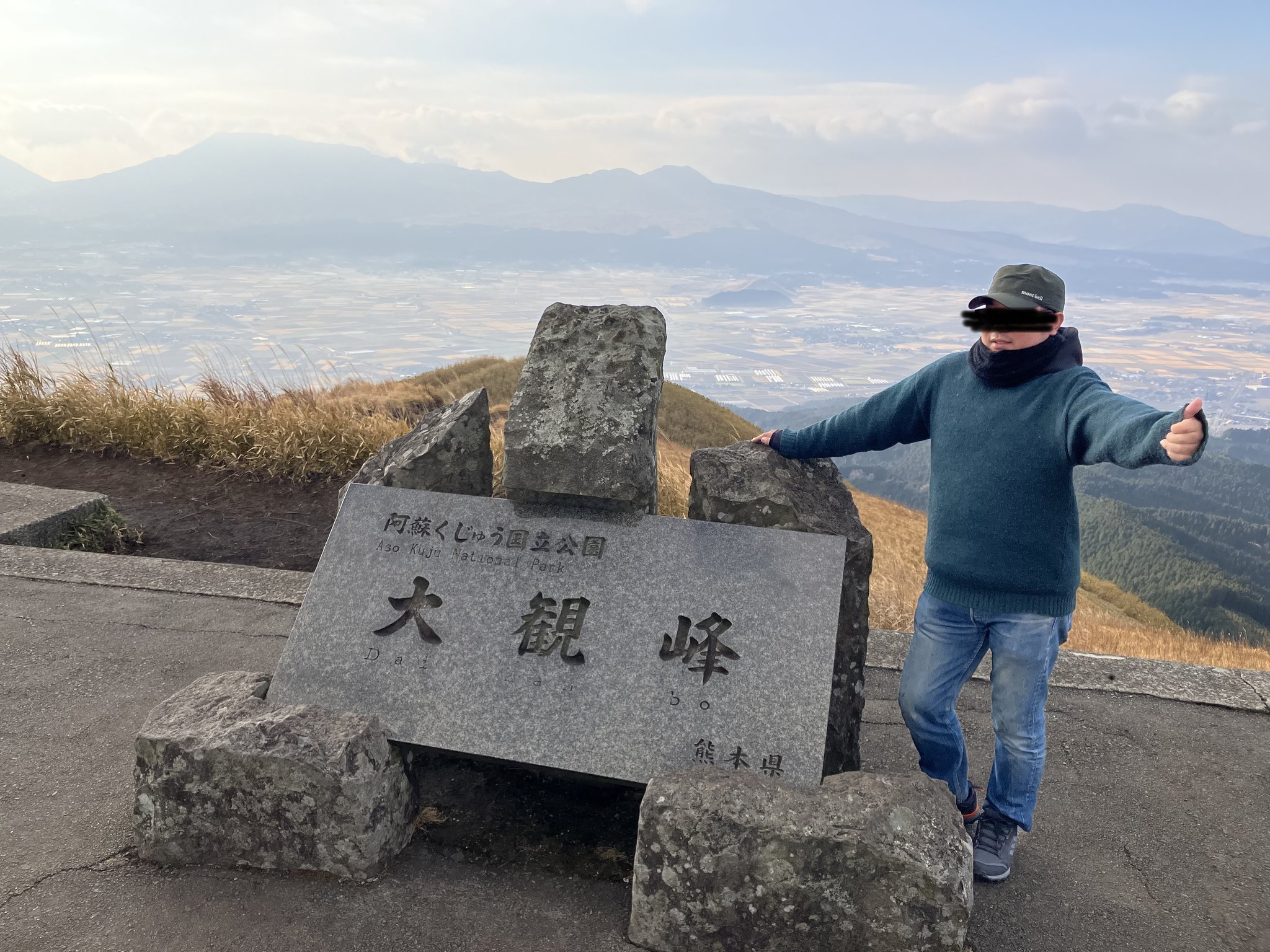 大観峰の石碑の前でサムズアップ